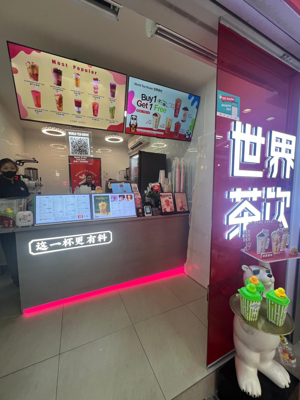 Grey order and pickup counter featuring pink LED floor skirting lighting and overhead digital menu boards