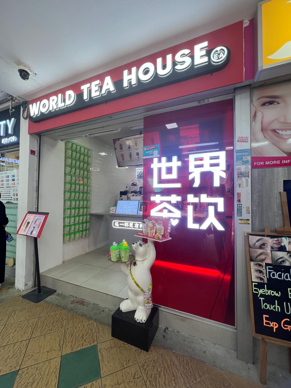 Entrance detail featuring a white bear mascot statue sitting next to a large purple illuminated Chinese character sign