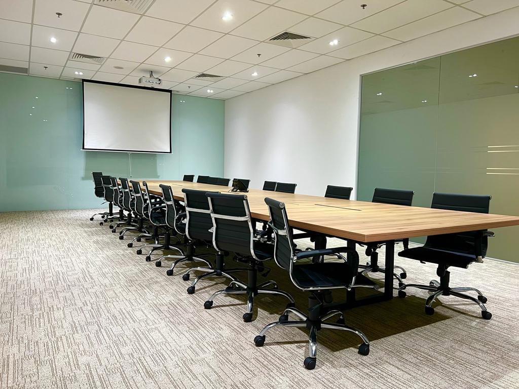 Executive glass meeting room equipped with ceiling projector screen and full-height glass dry-erase wall