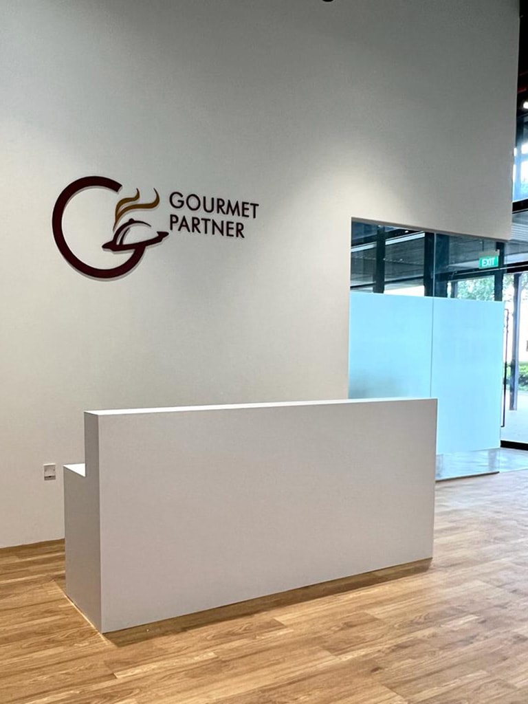 Minimalist white office reception counter with prominent corporate logo wall and vinyl wood flooring