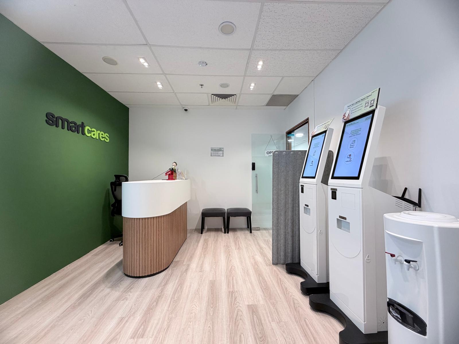 Wide view of a customer reception area featuring a forest green feature wall and light wood flooring.