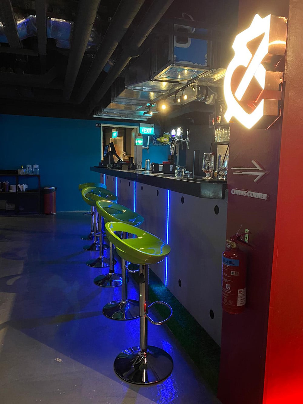 Bistro bar renovation featuring custom counter lighting, bar seating, and MEP ceiling ducting in Singapore
